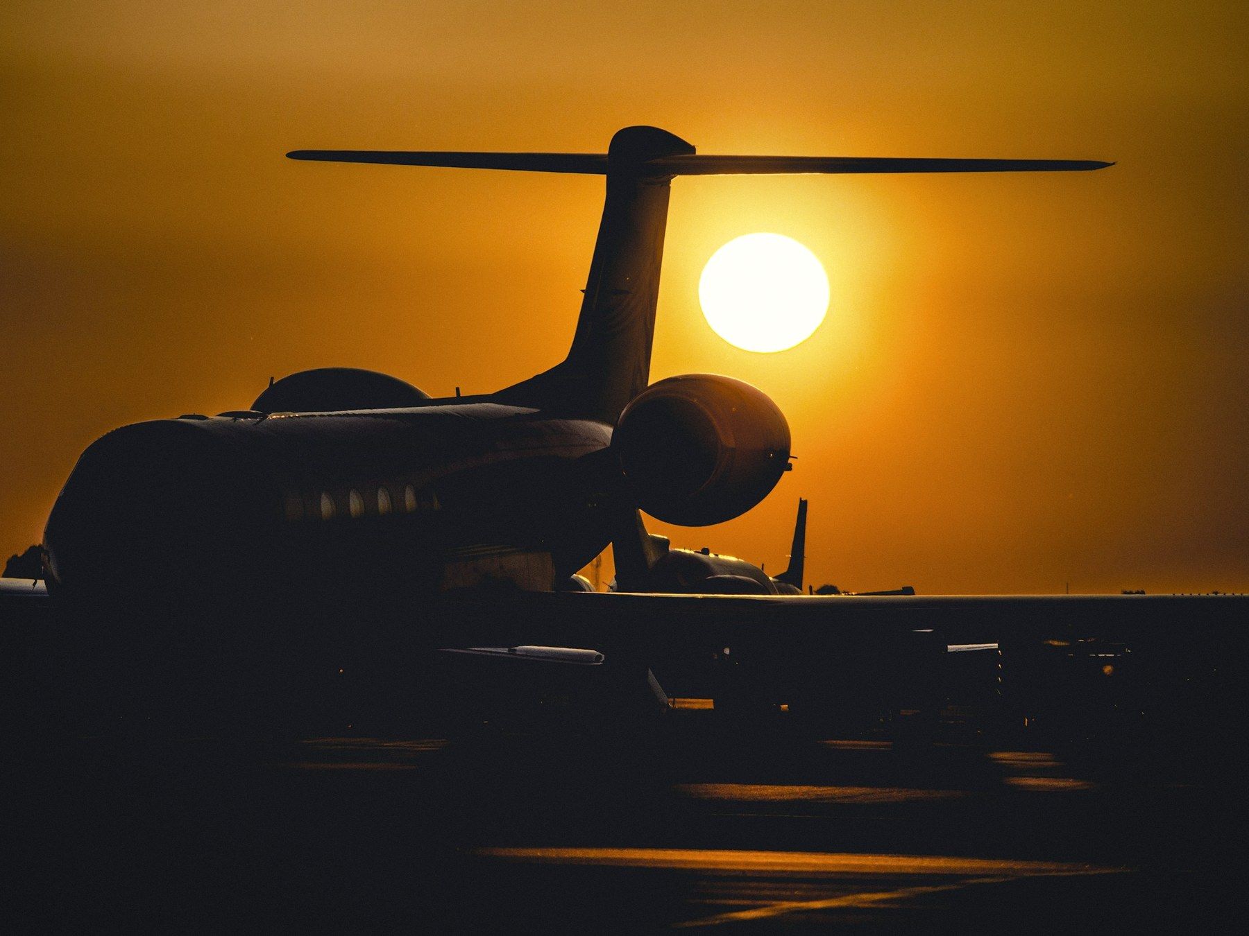 Long-range business jet silhouetted at sunset